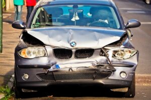 A photograph depicting a damaged car, which has been involved in a collision with another vehicle